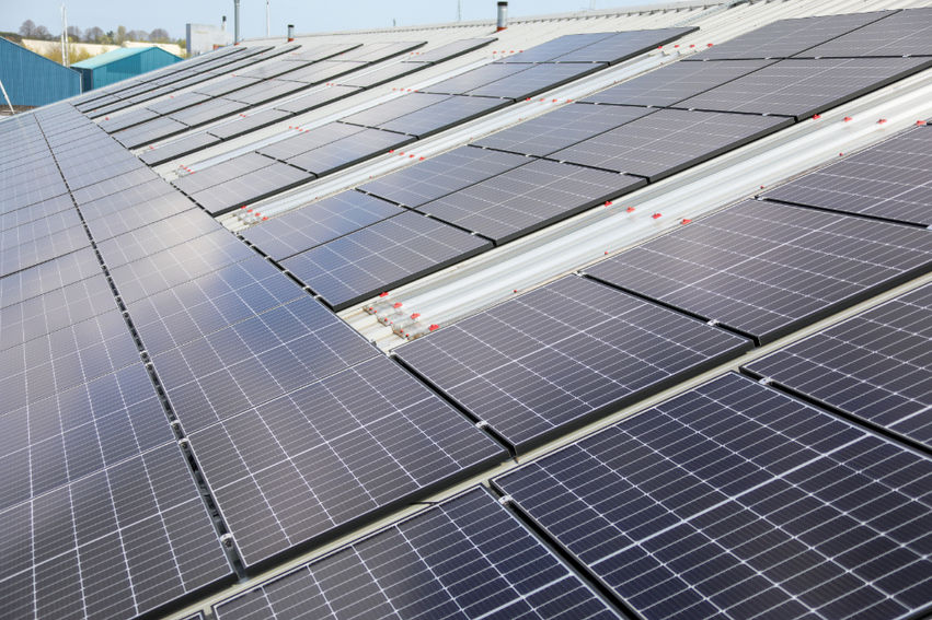 Symmetrical prospective shot down parallel rows of rooftop solar panel arrays.