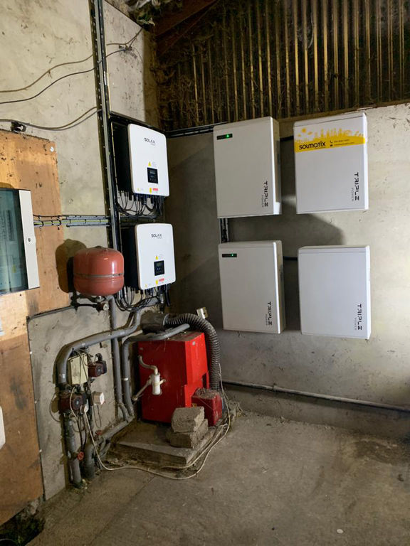 Wall-mounted solar power inverters and conduit piping installed inside an utility room.