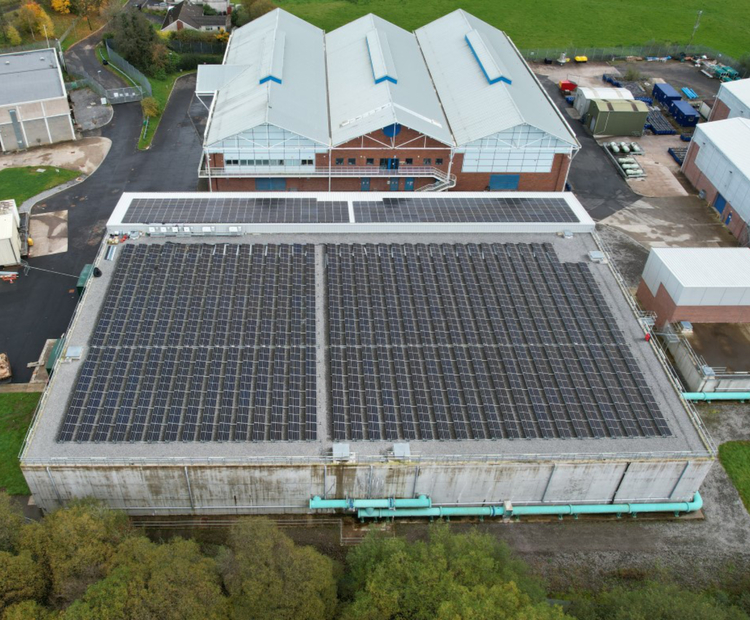 Overhead aerial view of an industrial building complex equipped with rooftop solar panels.