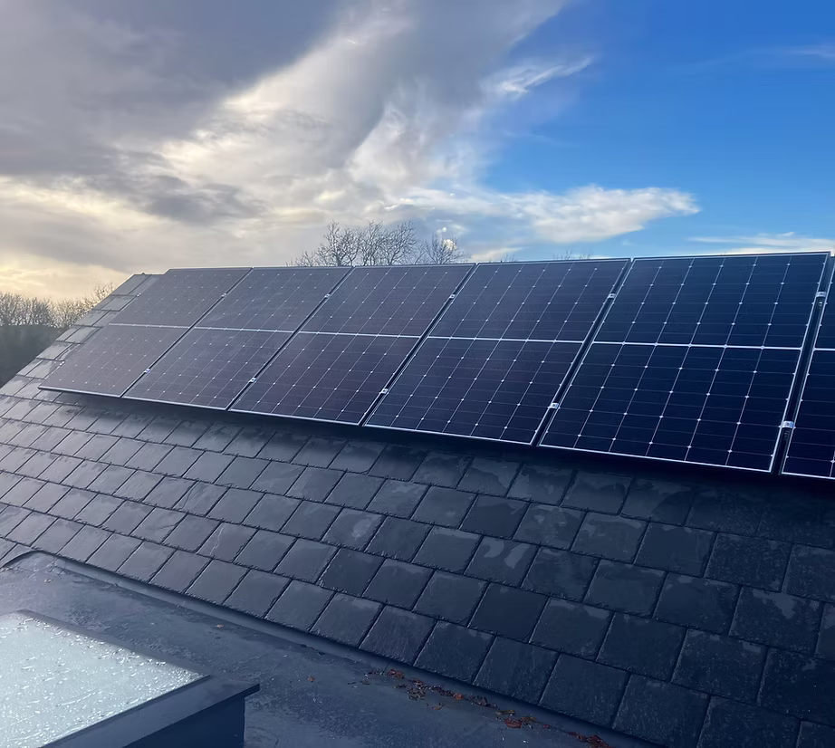 Close-up shot of solar panels mounted along a house roof.