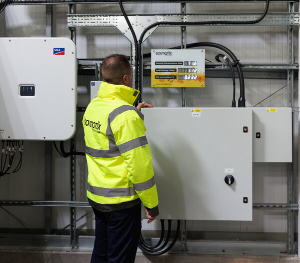 a Solmatix team member checking the solar panel battery