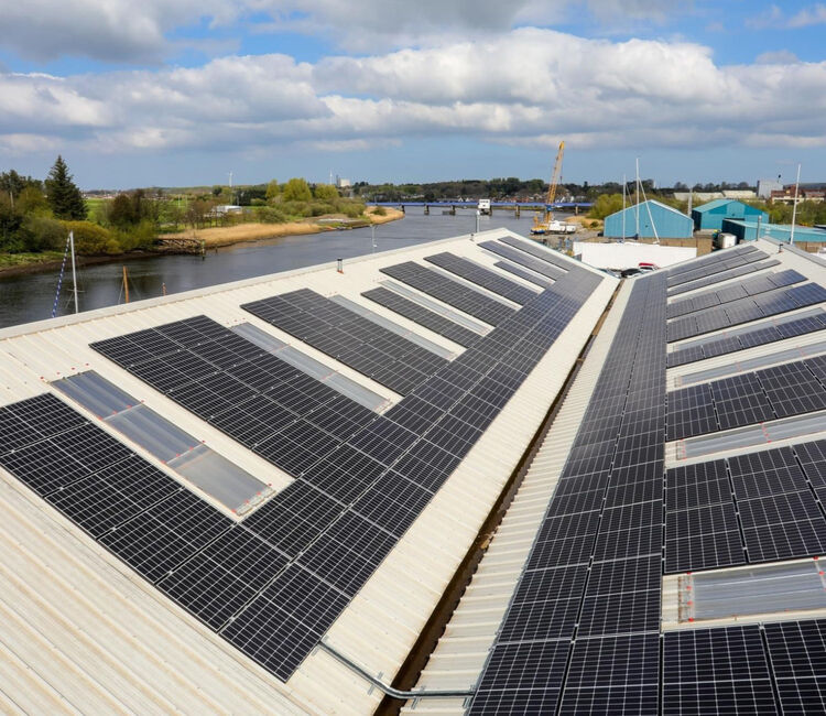 Rooftop view of solar panel rows mounted on an industrial facility.