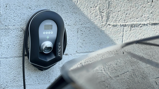 Close-up of an EV charging cable plugged into an electric vehicle port.