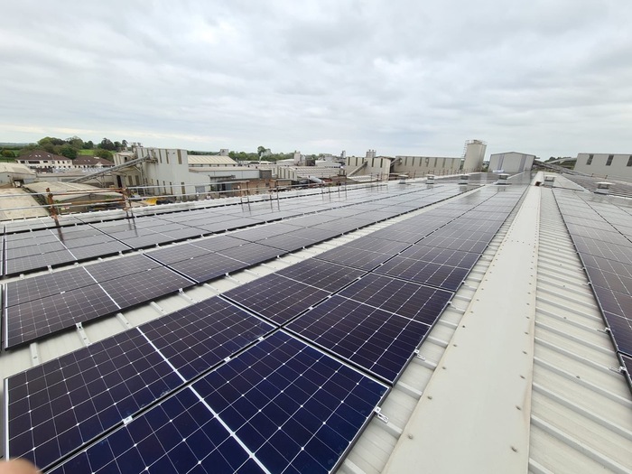 Low-angle shot of solar panels installed along a commercial flat roof.