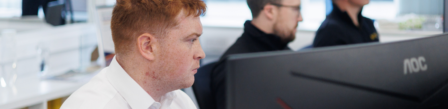 Office team members at their workstations discussing customer support inquiries.
