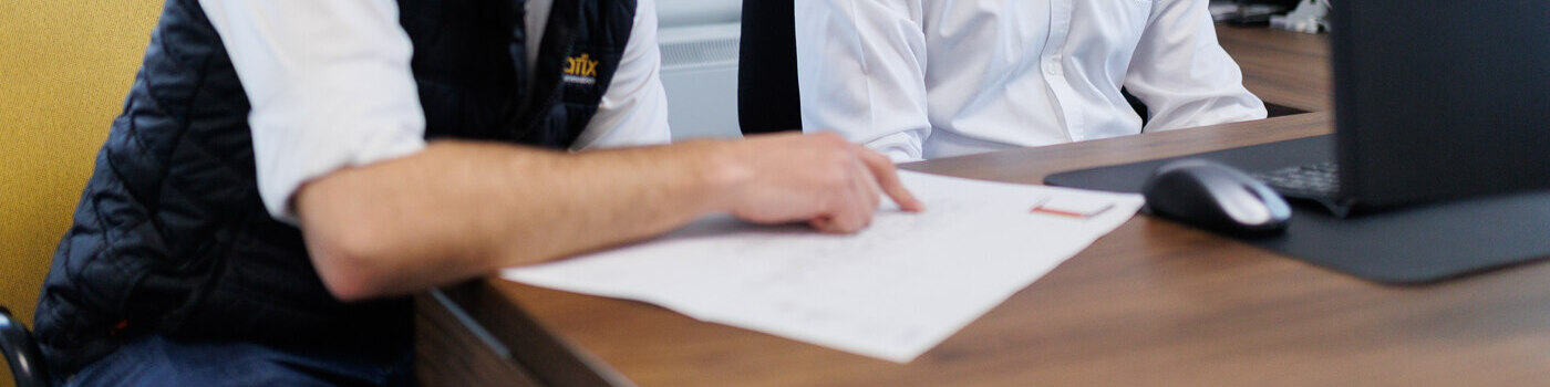 Staff member pointing to some notes on a sheet of paper