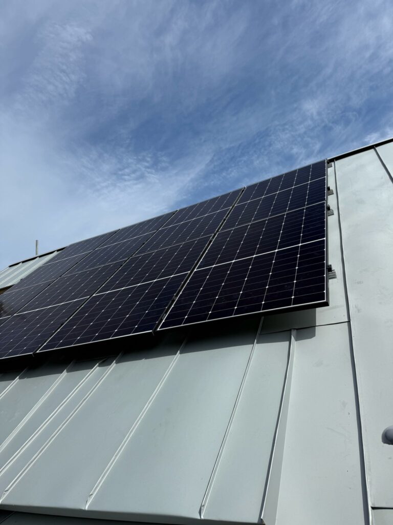 Low-angle shot of solar panels installed on a residential roof.