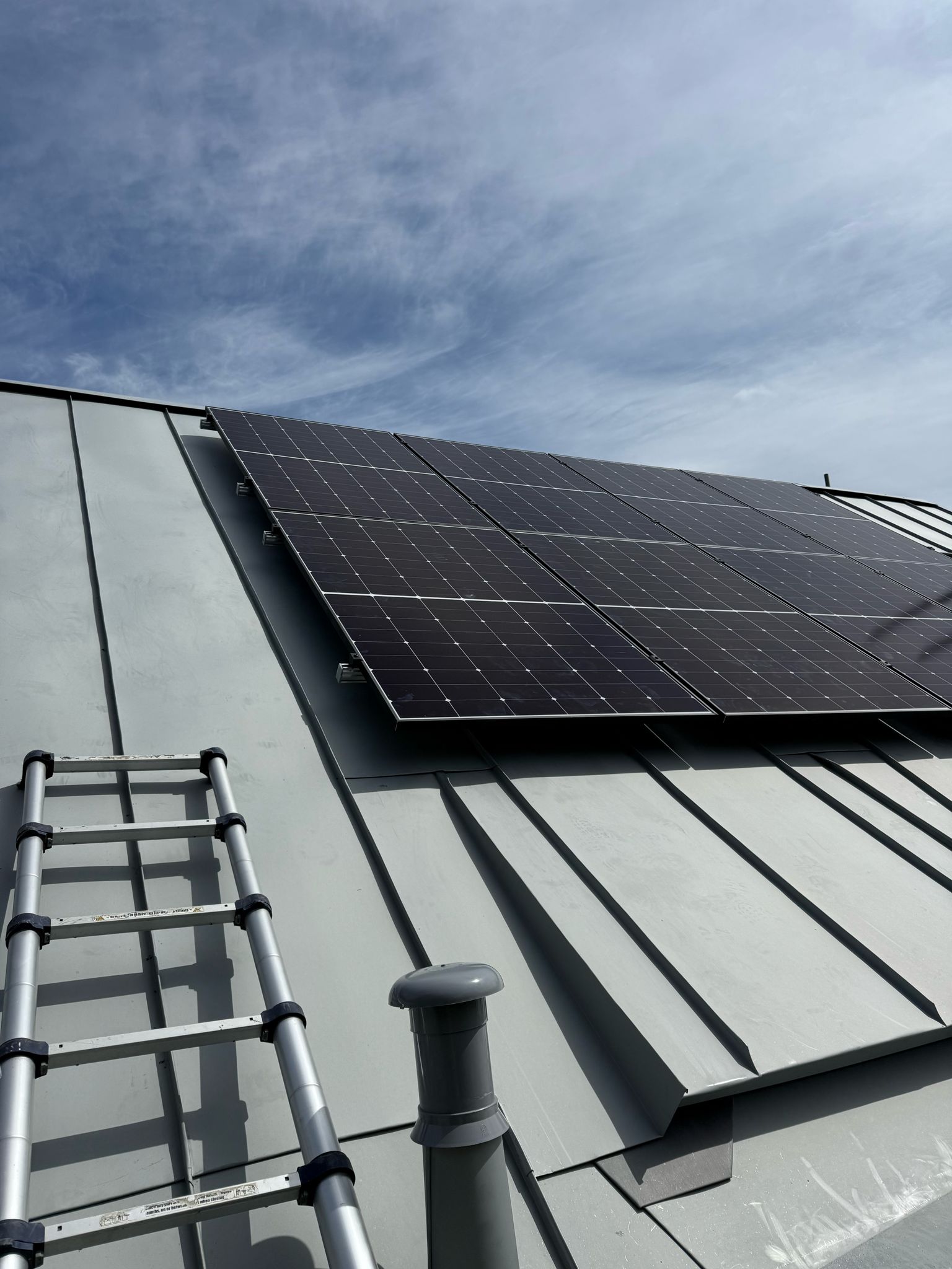 Close-up of black solar panels mounted flush on a dark pitched roof.