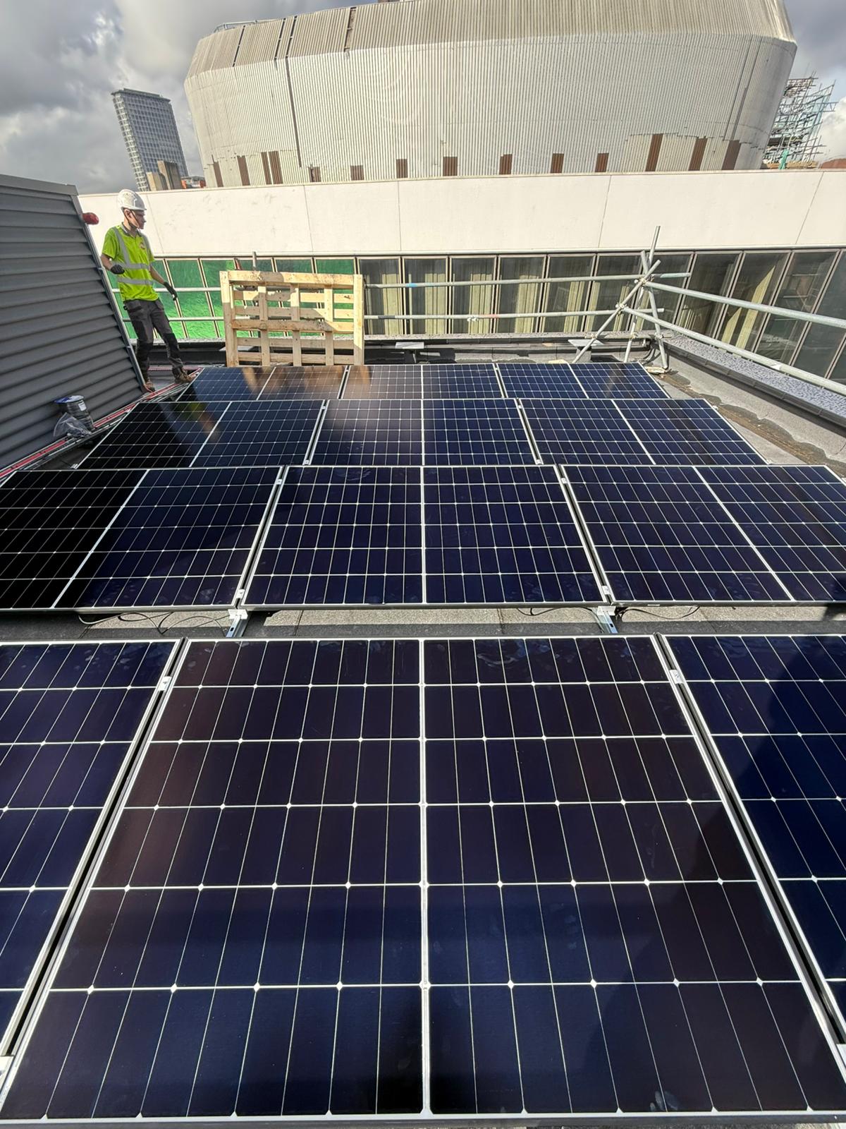 Rooftop view of solar panels on an urban development site.