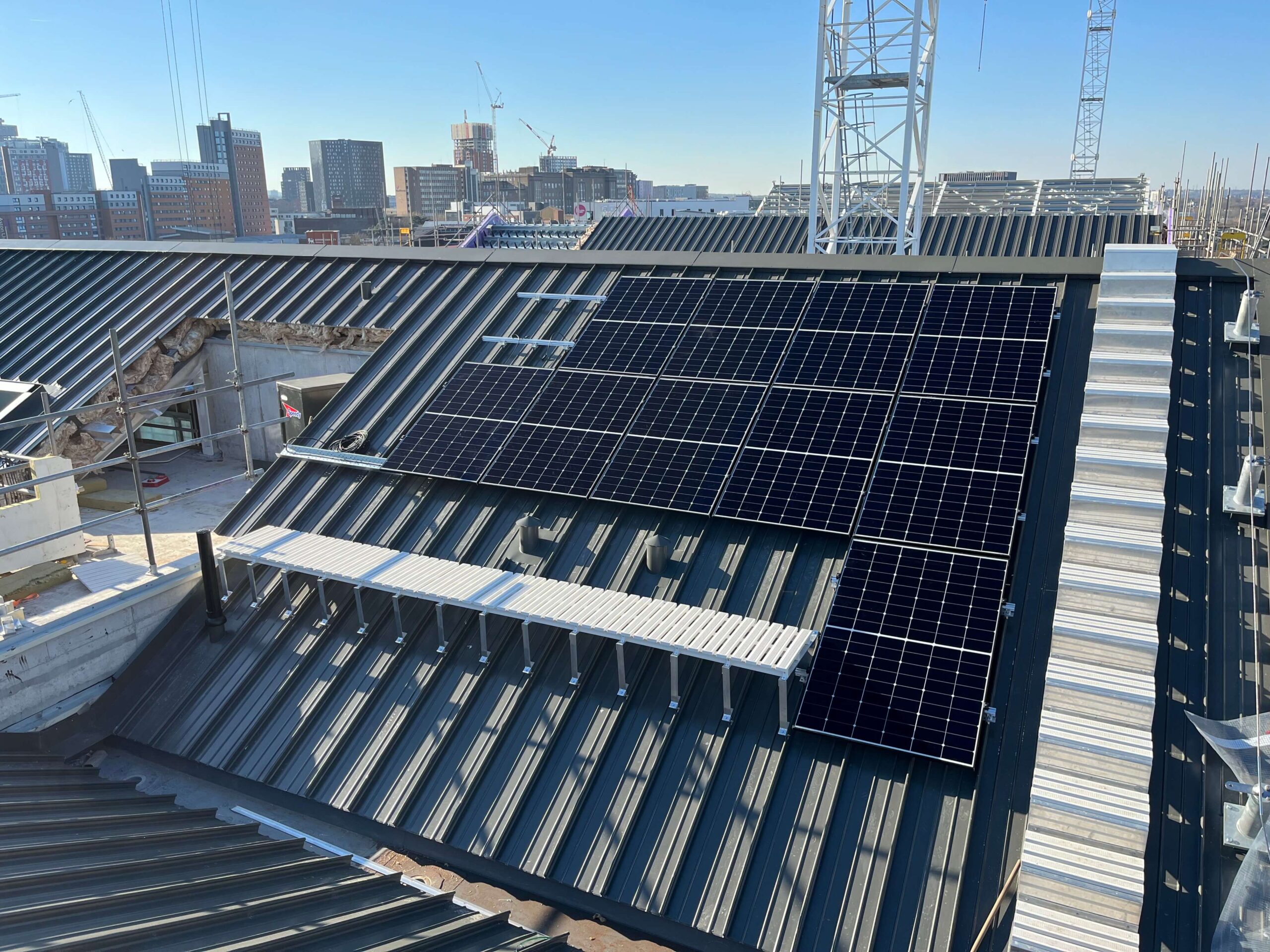 Large rooftop solar panel array installed on an urban apartment building.