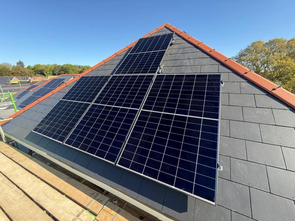 Array of dark solar panels neatly fitted onto the triangular pitched roof section of a residential home.