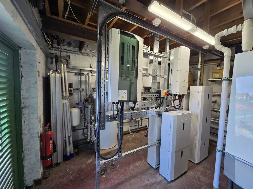 A wall-mounted solar inverter unit connected to internal electrical wiring.
